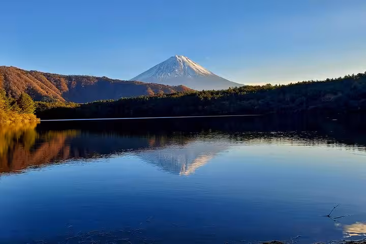 Tranquil lake reflecting Mount Fuji at sunrise, perfect for a customizable tour experience in Japan.