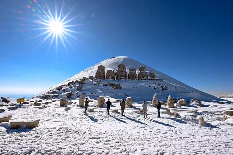 Mount Nemrut snowy summit with colossal statue heads at sunrise, featured on 5-day Mesopotamia tour by plane