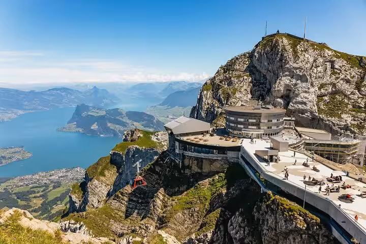 Breathtaking view from Mount Pilatus summit, showcasing a panoramic restaurant and sweeping vistas of Lake Lucerne.