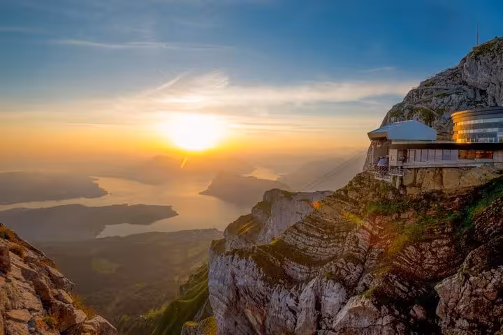 Stunning sunset view from Mount Pilatus, highlighting the rugged cliffs and serene lakes of Swiss landscape.