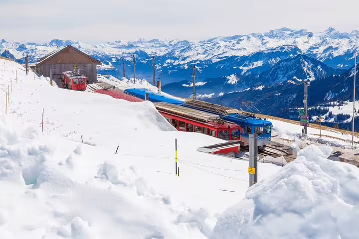 Snow-covered cogwheel train station on Mount Rigi with panoramic Swiss Alps views.