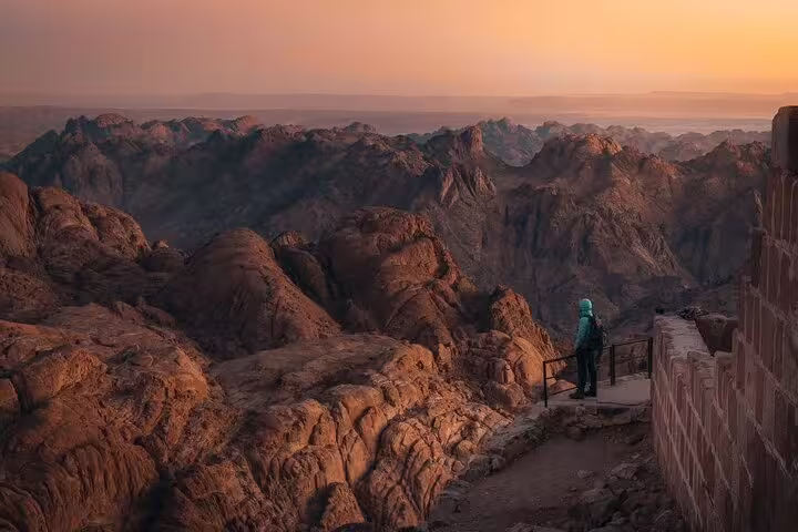 Traveler overlooks Sinai mountains at dawn near Saint Catherine Monastery on Mount Sinai climb from Dahab