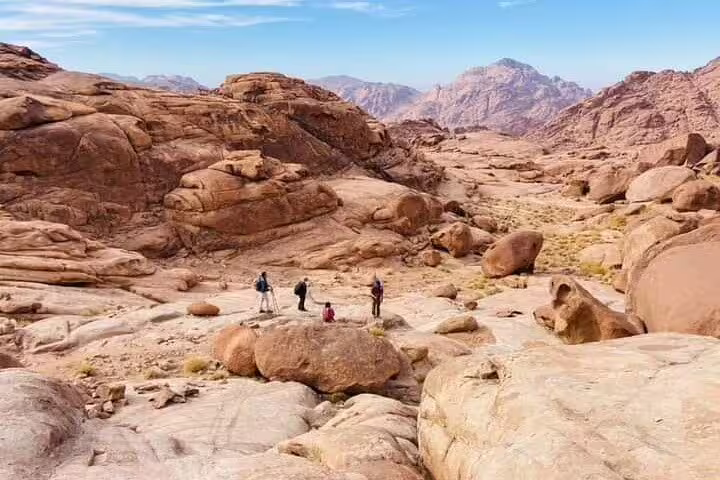 Hikers crossing Sinai desert boulders on Mount Sinai climb tour from Sharm El Sheikh to St Catherine