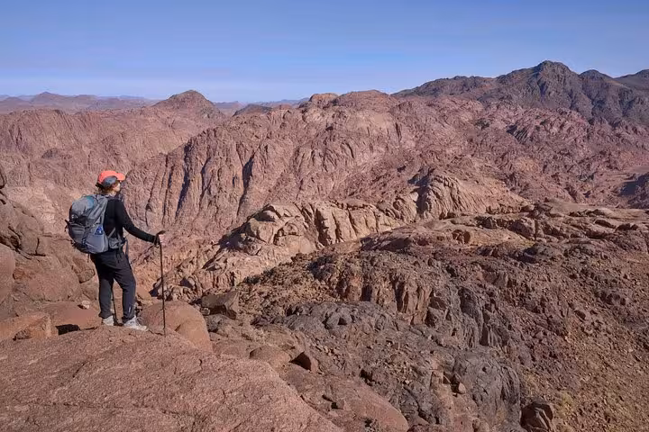 Hiker overlooking rugged Sinai range on Mount Sinai summit trek, part of St Catherine’s Monastery tour from Sharm