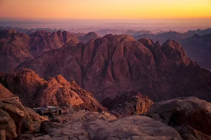 Sunrise view from Mount Sinai summit on Dahab hike, rugged Sinai mountains glowing in golden light