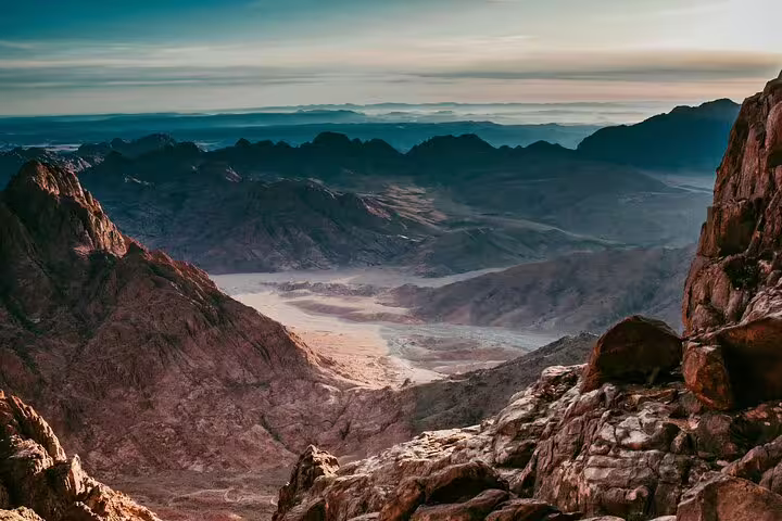 Sunrise panorama from Mount Sinai summit on overnight Cairo trip, rugged Sinai mountains and desert valley views