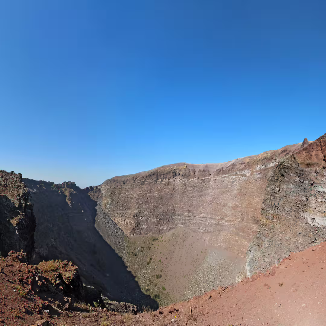 Panoramic view into Mount Vesuvius crater under clear blue sky on guided daily tour from Naples with wine tasting