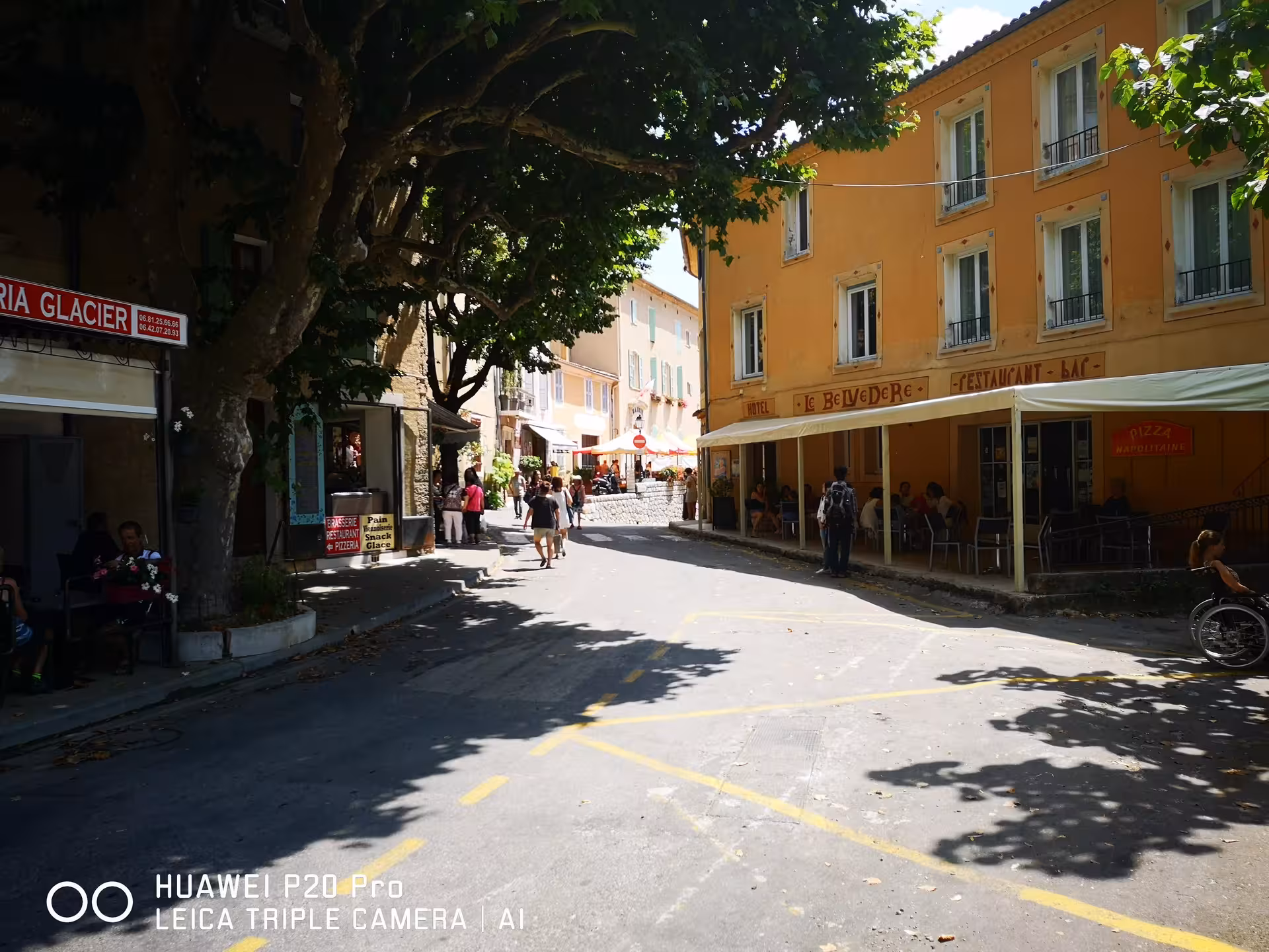 Shaded village street cafes in Moustiers Ste Marie, a stop on Marseille shore excursion to Lake Ste Croix
