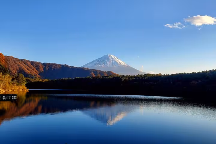 Mt. Fuji reflected in a tranquil lake under a clear blue sky, part of a private customizable Hakone tour.