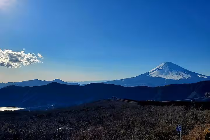 Majestic view of snow-capped Mt. Fuji under a clear blue sky, highlighting the stunning landscapes of the Hakone tour.