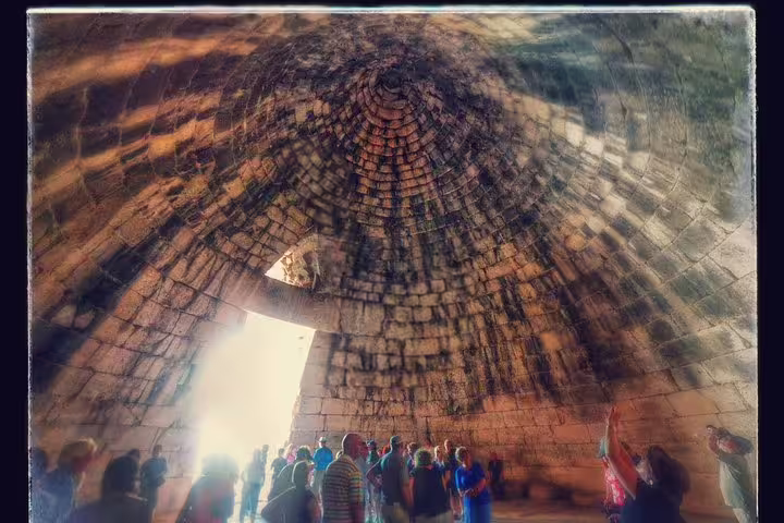 Visitors inside the Mycenae beehive tomb (Treasury of Atreus) on a private tour from Athens