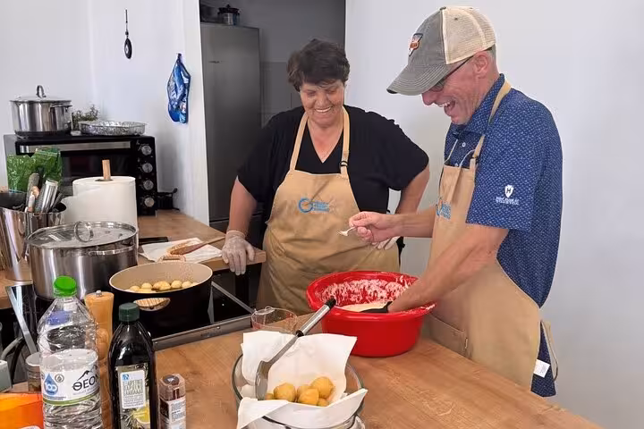 Guests preparing Greek dough in a hands-on Mykonos cooking class, traditional recipes before sunset viewpoint