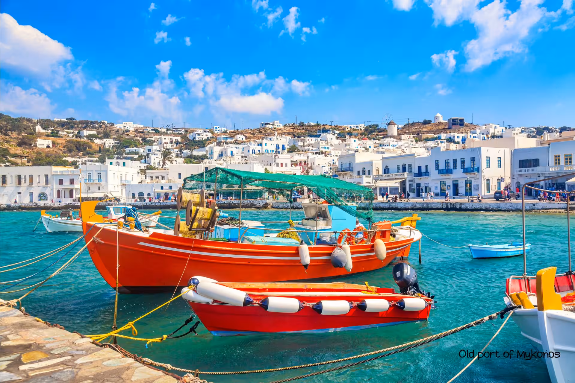 Colorful fishing boats in Mykonos Old Port with Cycladic skyline, part of Athens island hopping to Santorini Naxos Mykonos