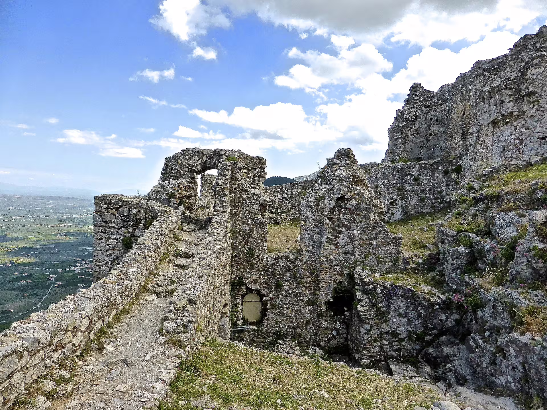 Stone walkway through Mystras fortress ruins with valley views, part of 2-day private tour from Sparta to Monemvasia