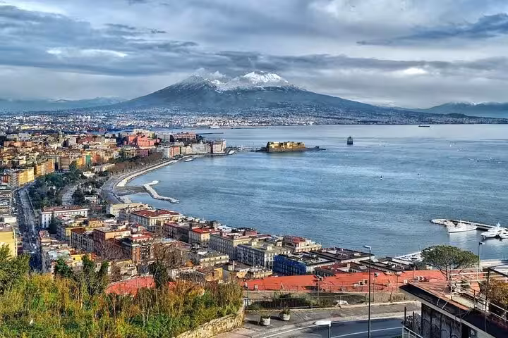 Panoramic view of Naples Bay with Mount Vesuvius in the background, highlighting the city's stunning coastline.