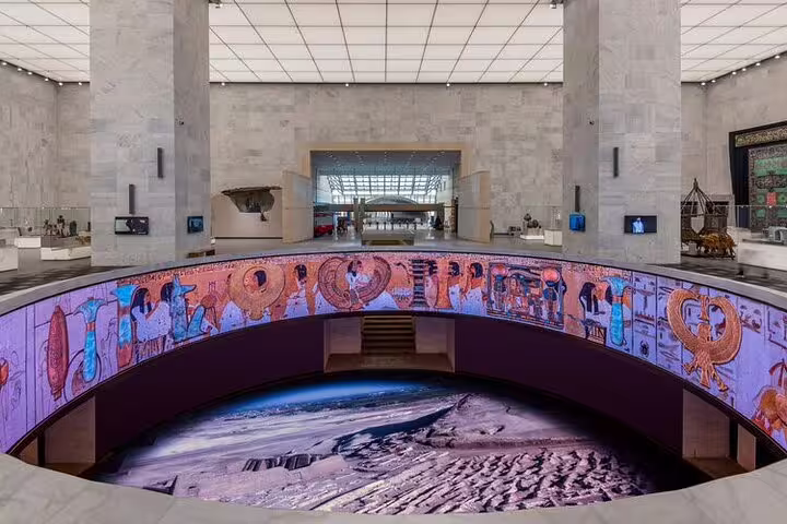 Grand hall at the National Museum of Egyptian Civilization Cairo with hieroglyphic mural and exhibits on tour