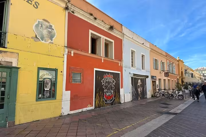 Vibrant street in Nice with painted walls and bikes, featured on a private sightseeing tour with driver from Cannes