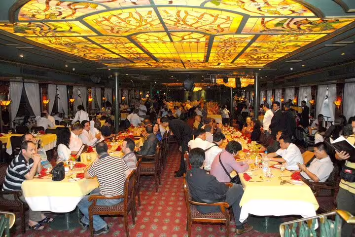 Nile dinner cruise dining hall in Cairo with buffet tables and live ambiance on the Giza pyramids combo tour