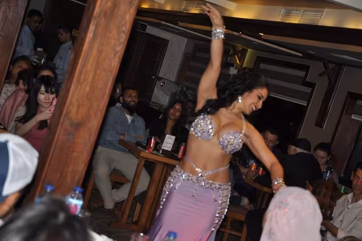 Belly dancer in silver costume entertains guests on Nile River night dinner cruise in Cairo with onboard show
