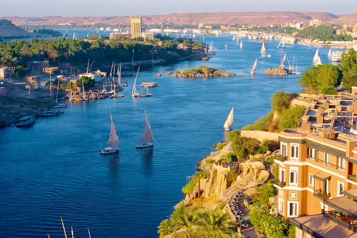 Scenic Nile River view with felucca sailboats in Aswan, part of Hurghada to Cairo and Giza tour