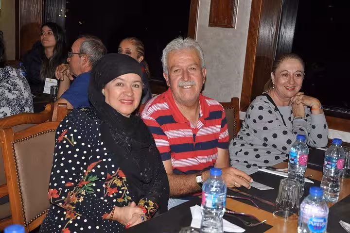 Guests dining onboard a Nile River night dinner cruise in Cairo, seated at table with drinks and cutlery