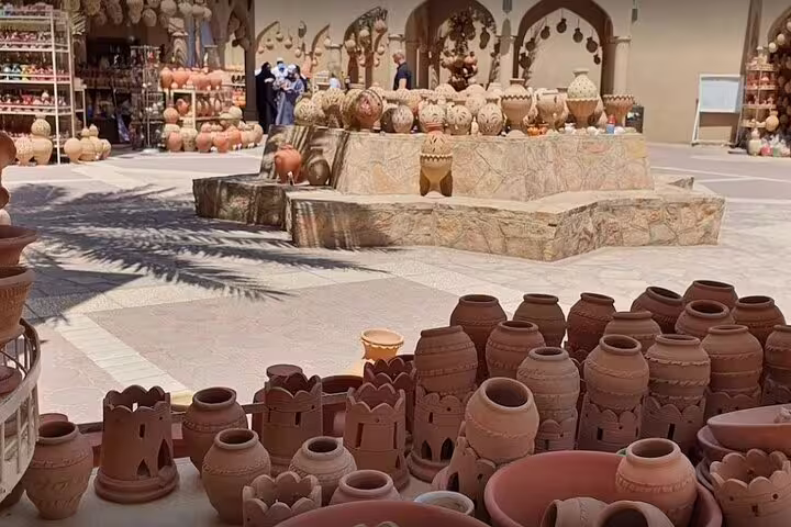 Discover traditional pottery at a bustling market in Nizwa, part of the Nizwa-Al Hamra Old Village-Misfah Al Abryeen Full Day Tour.