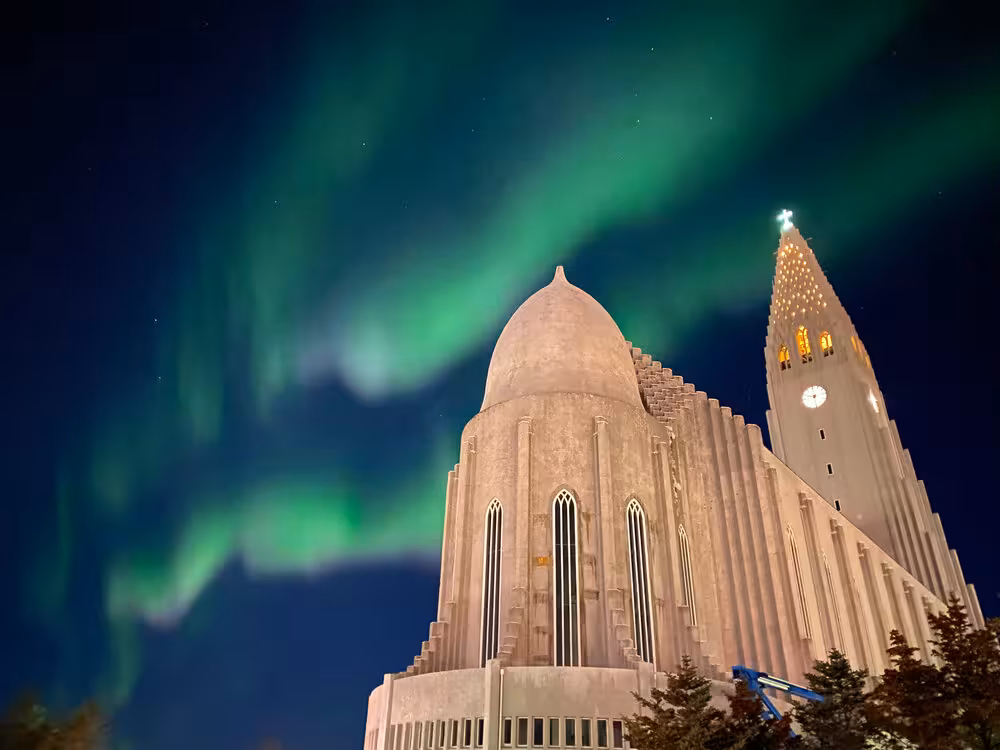 Northern Lights illuminate a grand cathedral, highlighting a magical moment in a women-only winter tour.