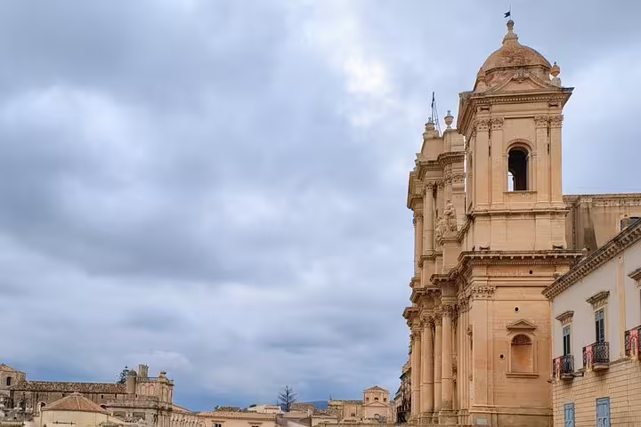 Stunning Baroque architecture of Noto Cathedral under a cloudy sky, showcasing intricate details and grandeur.