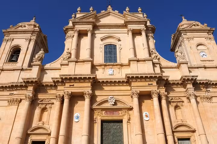 Admire the stunning Baroque architecture of Noto Cathedral under the bright Sicilian sky.