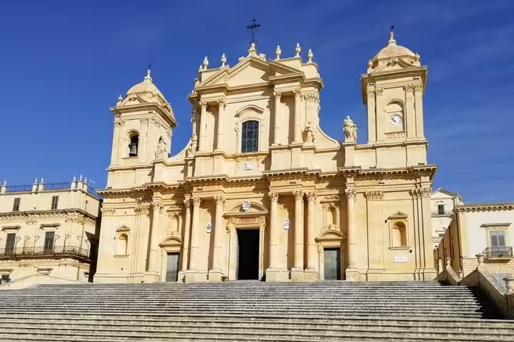 Stunning Baroque façade of the Noto Cathedral with intricate details and a grand staircase.