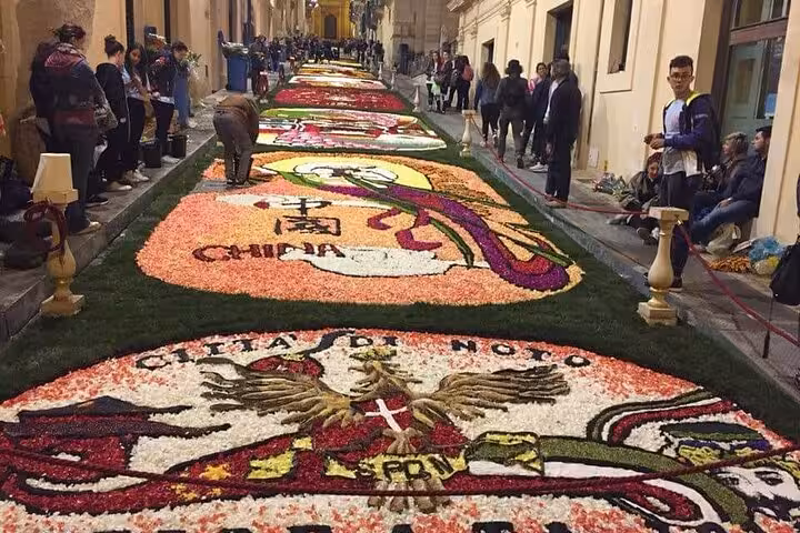 Vivid floral display on Noto's Infiorata street festival, showcasing intricate petal designs and vibrant colors.