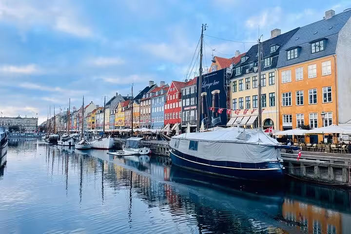 Scenic view of vibrant Nyhavn canal with boats and colorful buildings, perfect for a small group walking tour in Copenhagen.