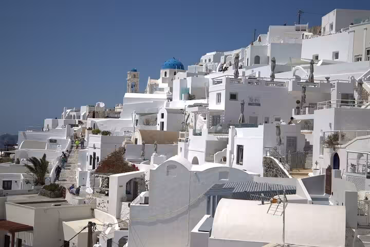 Oia village whitewashed buildings and blue-domed church, classic stop on Santorini iconic highlights tour