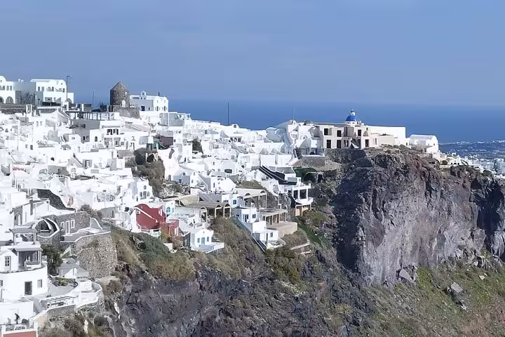 Oia cliffside view with whitewashed houses and blue-domed church, Iconic Highlights Tour Santorini