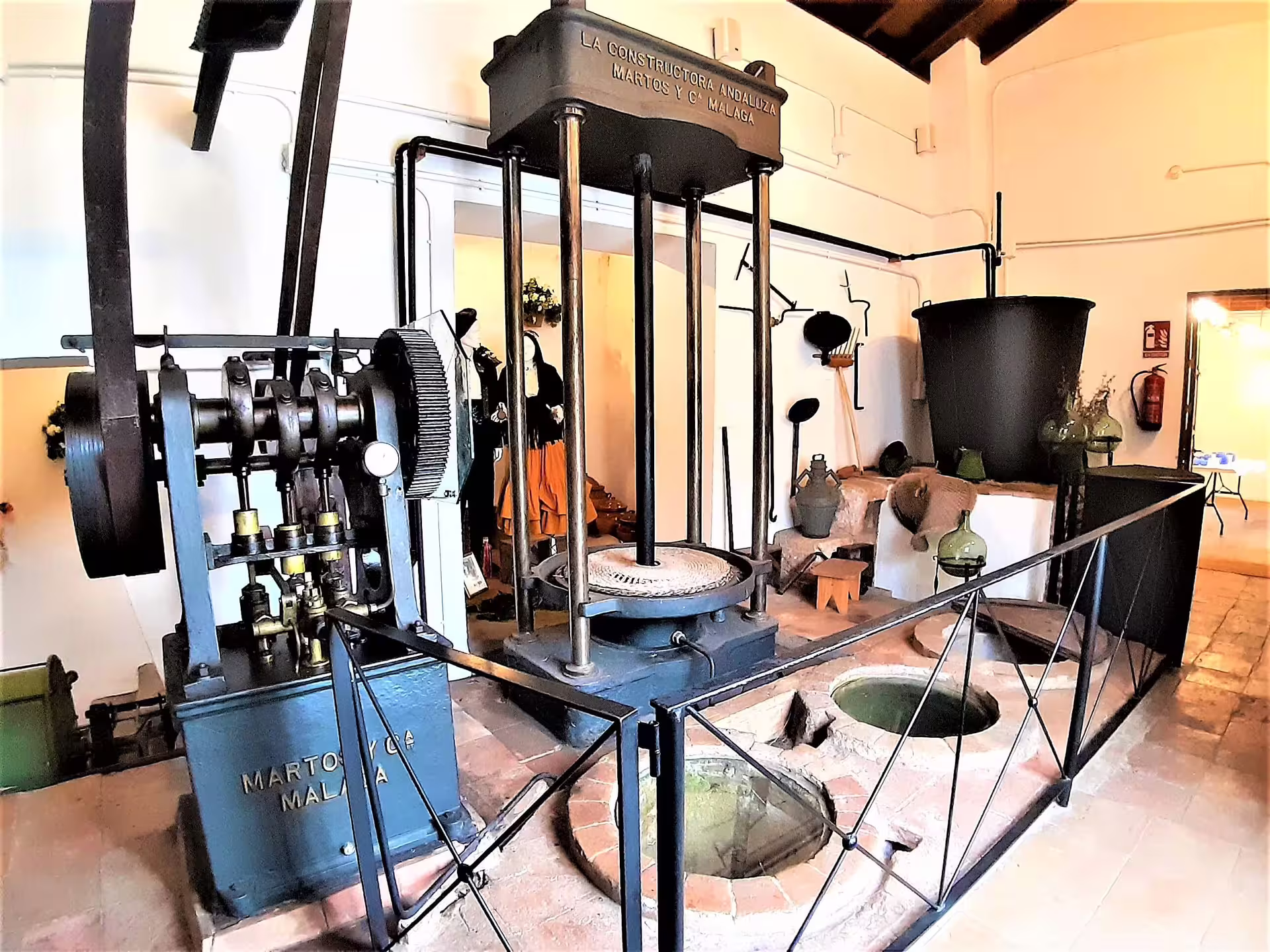 Historic olive oil press machinery in an Ojen museum, cultural highlight on an Ojen private walking tour in Andalusia