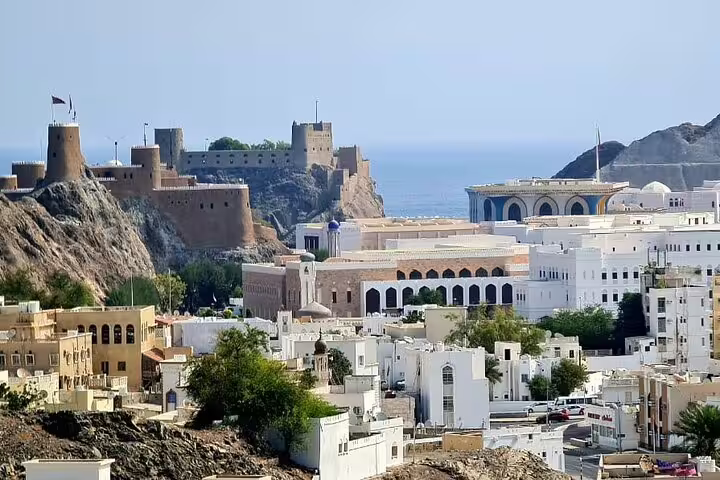Panoramic view of Old Muscat with its historic forts and modern buildings, a highlight of the Oman package tour.