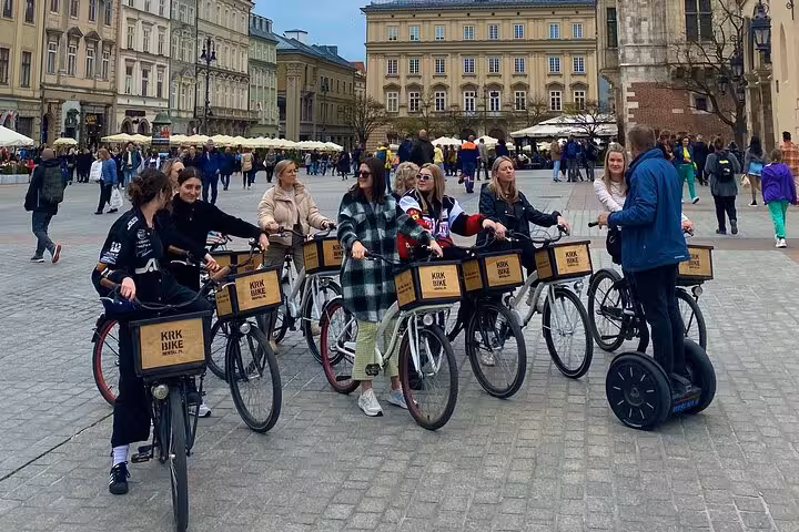Group enjoying Old Town Krakow guided bike tour, exploring historic sites and charming streets in vibrant city center.