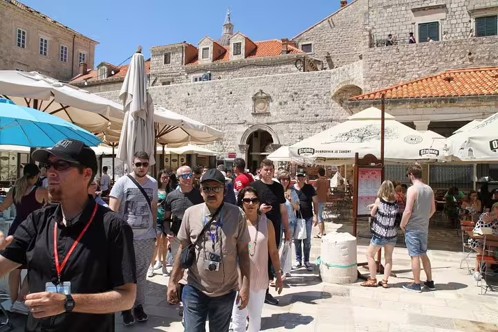 Crowds exploring Old Town market square and cafes on the Discover the Old Town Walking Tour under sunny skies