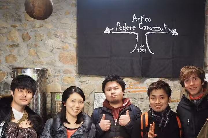 Group of visitors at Antico Podere Cavozzoli during an olive grove tour in Tuscany.