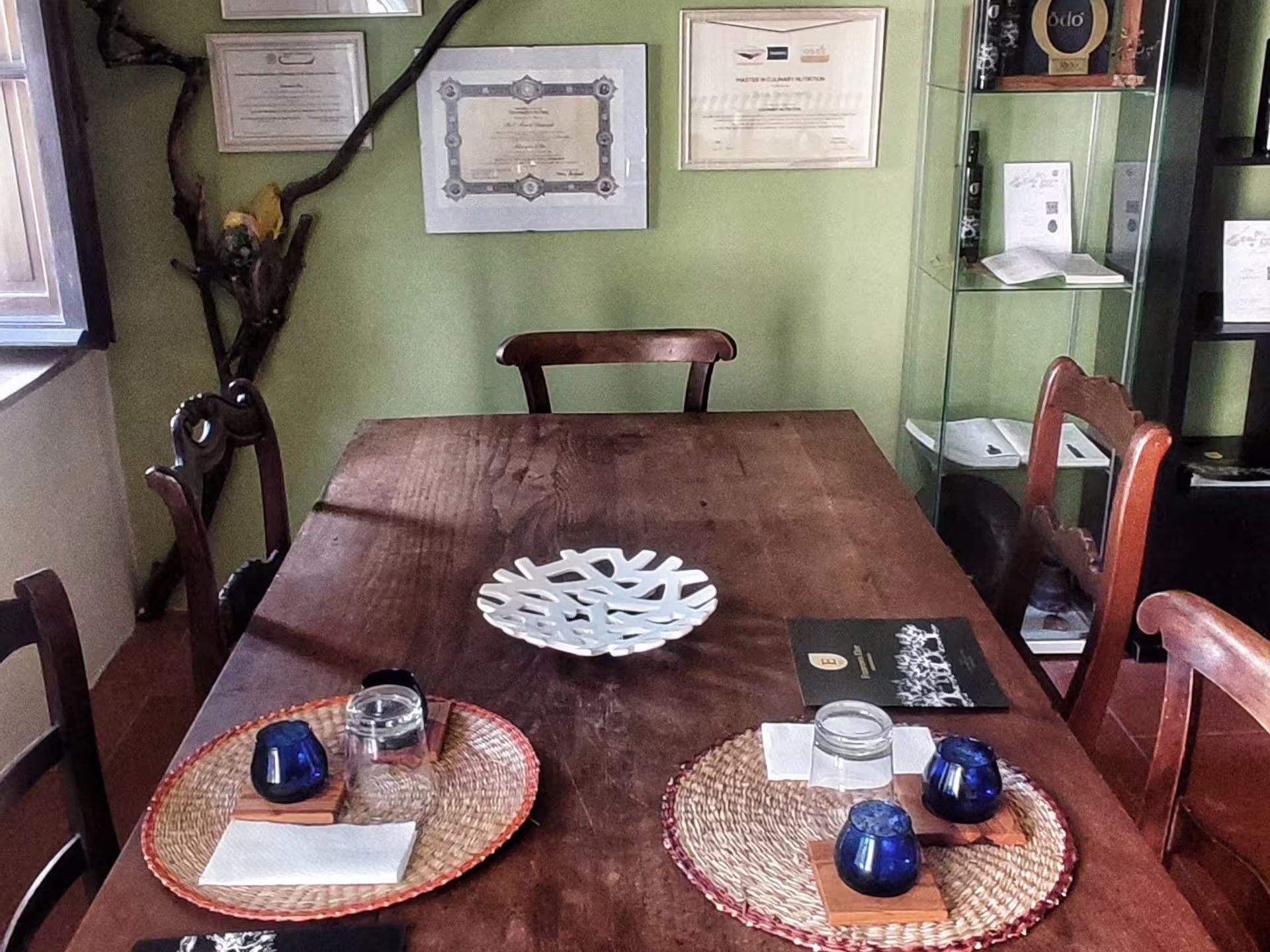 Cozy tasting room setup at an olive mill near Pisa, featuring tasting glasses and rustic decor for an authentic experience.