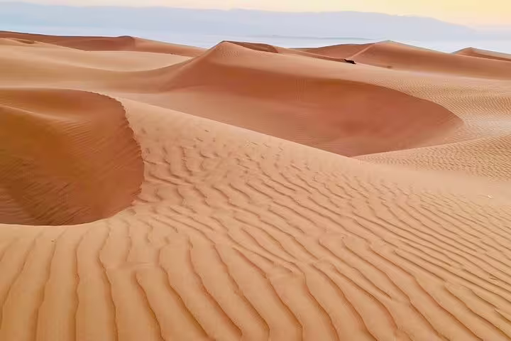 Expansive golden sand dunes of Oman's desert highlight the natural beauty of a 3-day private tour adventure.