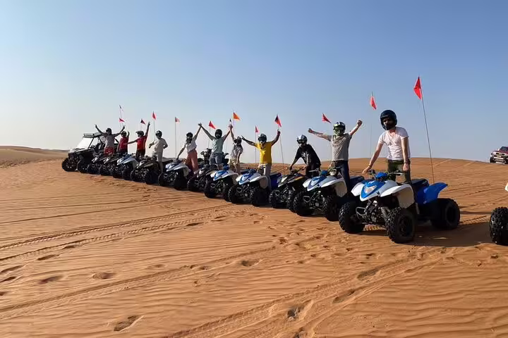 Group enjoying an exhilarating ATV ride across the rolling dunes of Oman, showcasing adventure on a private tour.