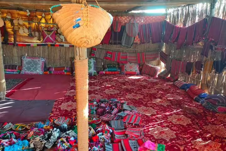 Traditional Omani Bedouin tent interior with vibrant textiles, part of a cultural experience on a private Oman tour.