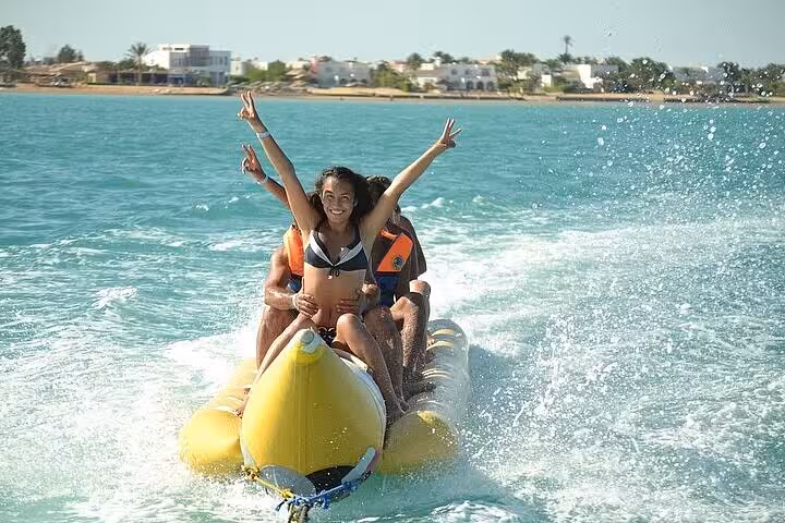 Couple on banana boat during Orange Bay VIP cruise from Hurghada, thrilling Red Sea water sports experience