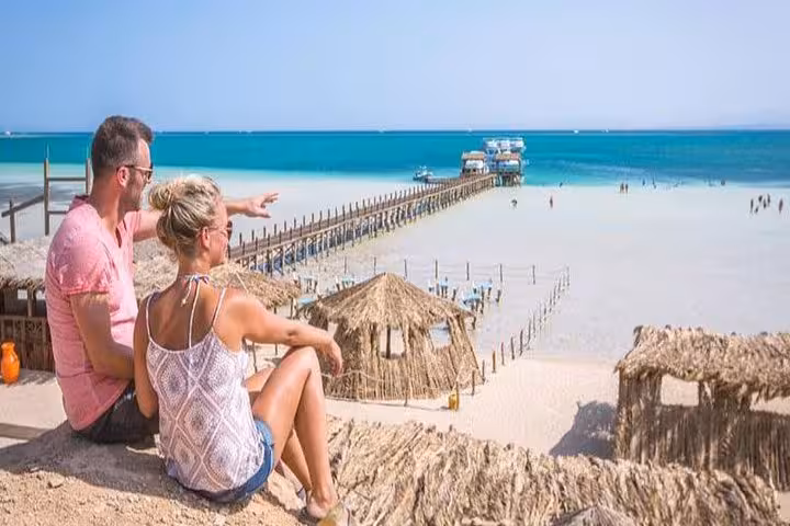 Couple overlooking Orange Bay Giftun Island sandbar and pier, turquoise Red Sea, Hurghada day trip