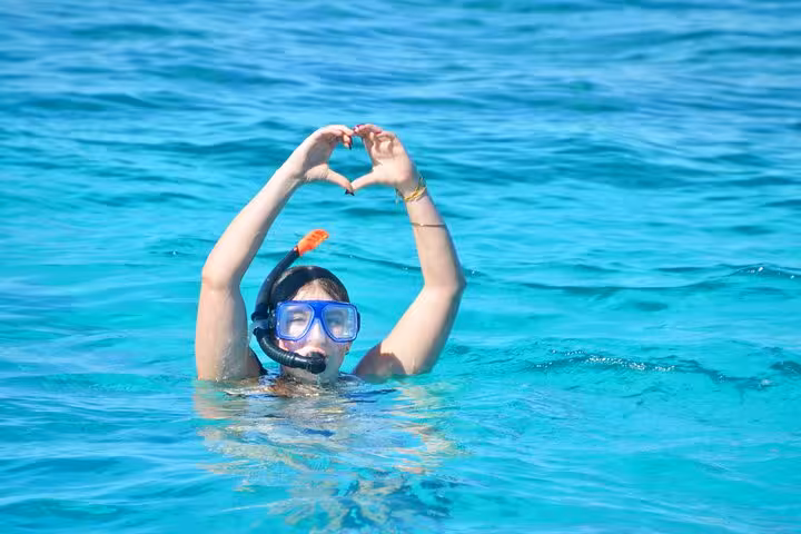 Snorkeler in crystal-clear Red Sea water on Orange Bay & Giftun Island boat trip from Hurghada