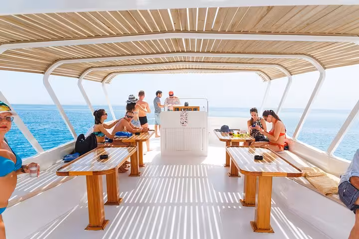 Relaxing on Hurghada boat deck with sea views and lunch setup during Orange Bay and Giftun Island day trip