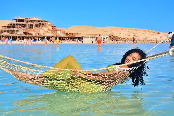 Relaxing in a sea hammock at Orange Bay, Giftun Island during Hurghada snorkeling boat tour with lunch