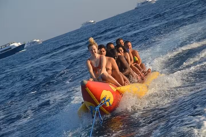Group enjoying banana boat ride on Hurghada Orange Bay VIP cruise, Red Sea water sports adventure