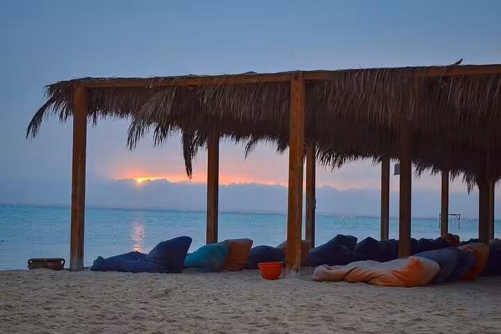 Sunset beach lounge at Orange Island, Hurghada, with shaded cabanas on private speedboat snorkeling trip